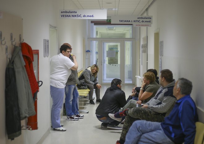 Včeraj je bil hodnik pred ambulantami družinske medicine poln, pacienti so sprijaznjeno čakali, vprašanje je, kako dolgo še. FOTO: Jože Suhadolnik