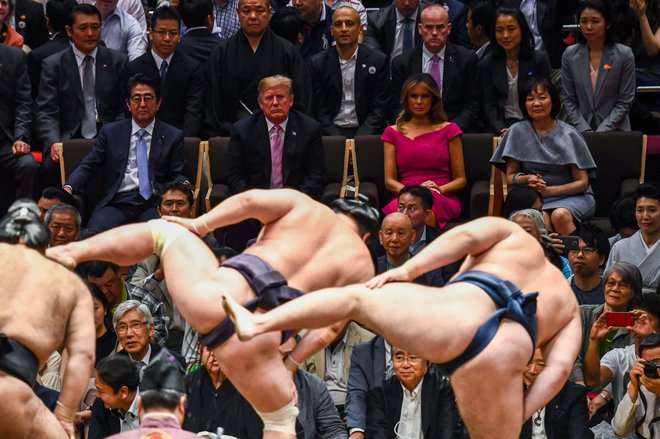Japonski premier Abe je visokega ameriškega gosta in soprogo Melanio povabil na finale turnirja v sumu. FOTO: AFP