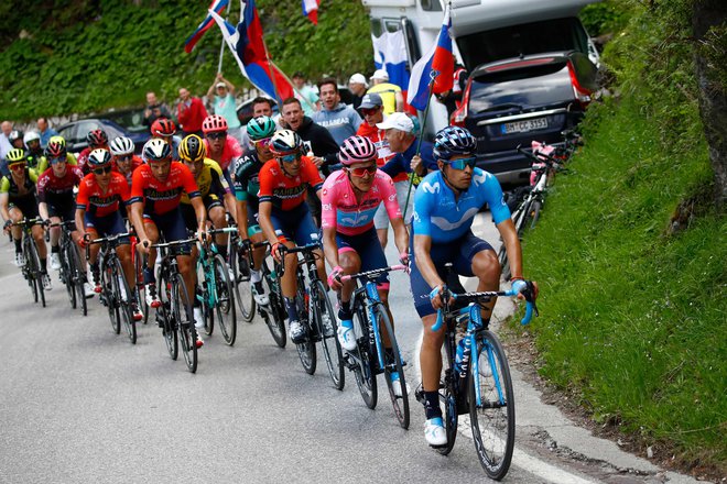 V morju slovenskih zastav je Roglič (v rumenem dresu) pred ciljem poskusil z napadom, a so kolesarji ekip Movistar in Bahrain Merida hitro pokrili njegov skok. FOTO: AFP