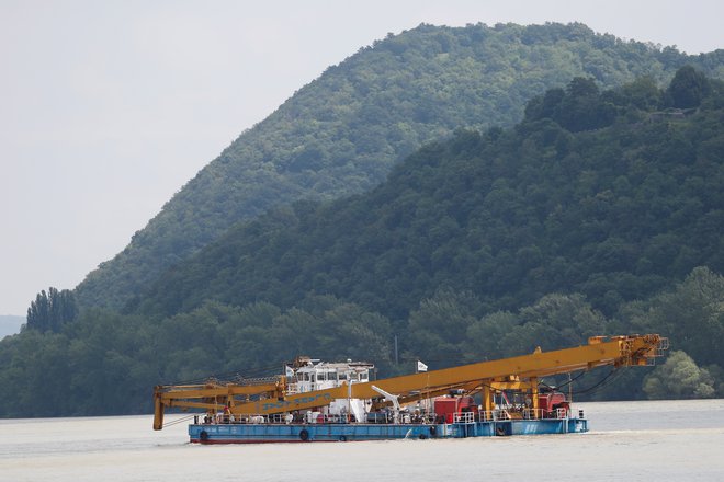 S pomočjo plavajočega žerjava bodo iz reke poskušali izvleči razbitine turistične ladjice. FOTO: Reuters