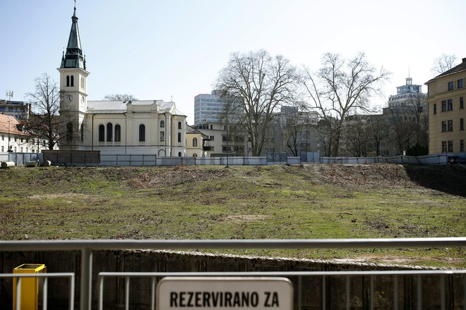 Na že vrsto let ograjenem zemljišču na elitni lokaciji v središču prestolnice gradbenih strojev še ne bomo videli v kratkem. FOTO: Blaž Samec/Delo