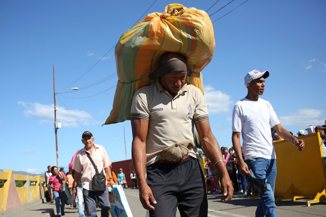 Prebežniki, ki prečajo kolumbijsko-venezuelsko mejo. FOTO: Carlos Eduardo Ramirez/Reuters