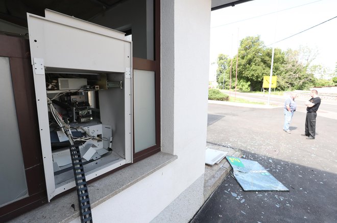 Policisti so ugotovili, da so neznani storilci z eksplozijo poškodovali bankomat in iz njega ukradli za zdaj še neznano količino denarja. FOTO: Dejan Javornik
