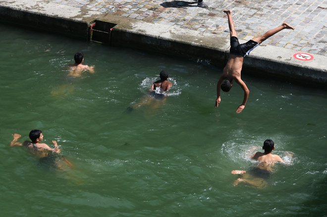 Fantje so v Parizu ohladitev poiskali v vodnem kanalu. FOTO: Dominique Faget/Afp