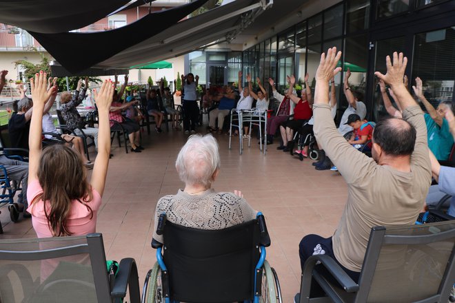 Med poletnim varstvom se otroci zaposlenih družijo s stanovalci že pri jutranji telovadbi. FOTO: Jože Pojbič/Delo