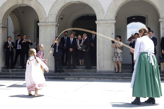 Pred Narodnim domom, kjer so podpisali pogodbo o sodelovanju, so goste iz Kitajske pozdravili domača godba na pihala in plesalci folklorne skupine Pušlc. FOTO: Mavric Pivk/Delo