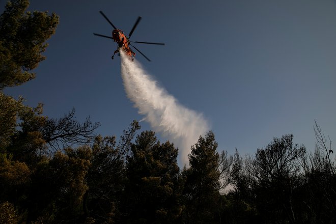 Pri gašenju si pomagajo tudi s helikopterji. FOTO: Alkis Konstantinidis/Reuters