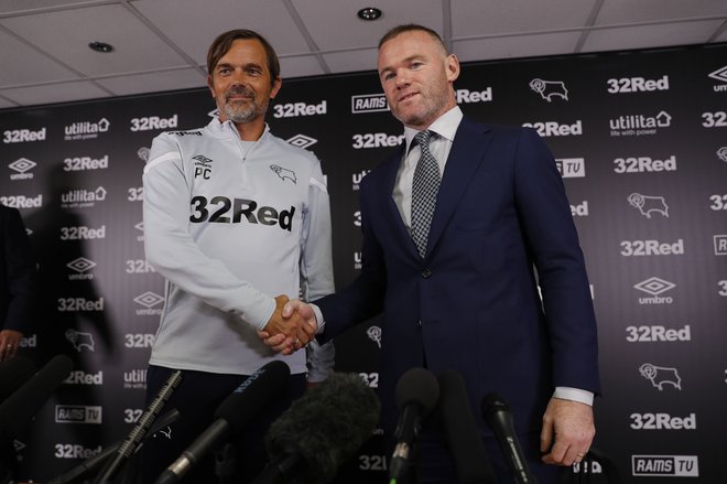 Wayne Rooney (desno) in trener kluba Derby County Phillip Cocu sta si takole segla v roke na novinarski konferenci ob začetku skupne poti. FOTO: AFP