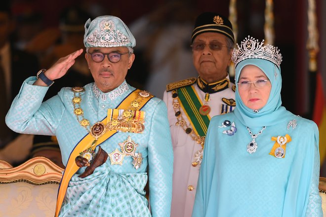 Na sliki malezijski kralj in kralijca ter premier Mohamad Mahathir v ozadju. FOTO: Mohd Rasfan/Afp