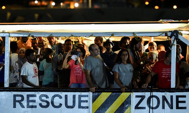 Sinoči je 81 migrantov, kolikor jih je še ostalo na ladji Open Arms, začutilo trdna tla pod nogami. FOTO: Guglielmo Mangiapane/Reuters