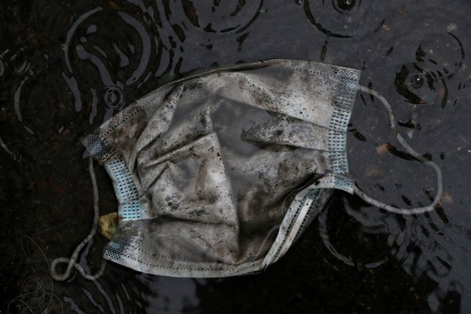 Umazana zaščitna maska na opuščeni madridski ulici. Foto Susana Vera Reuters