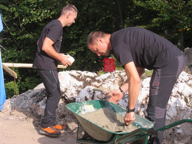 Člana Planinskega društva Celje Matica pri polaganju temeljnega kamna. FOTO: Špela Kuralt/Delo