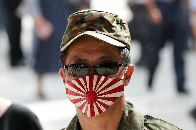 A lej ga šmenta: zarotniški Japonci maske nosijo že najmanj sto let. Že pred toliko leti so vedeli, kaj se bo zgodilo z virusi. Vsaj sto let so vadili, da so danes zarotniki par exellence. FOTO: Kim Kyung Hoon/Reuters
