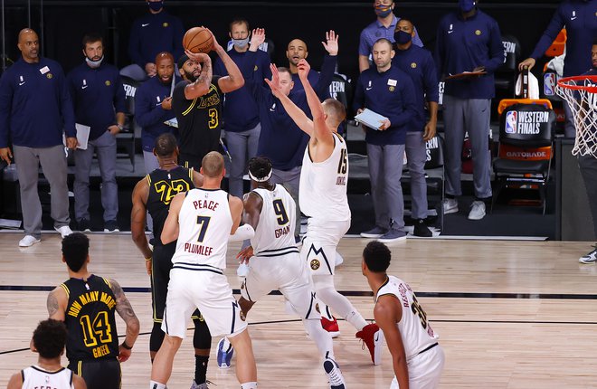 V izjemno razburljivi drugi finalni tekmi zahodne konference med LA Lakers in Denverjem je bil odločilen met Anthonyja Davisa za tri točke dve sekundi pred koncem. Niti odlični Nikola Jokić ni mogel preprečiti koša, po katerem Denver v zmagah zaostaja z 0:2. FOTO: Kevin C. Cox/AFP