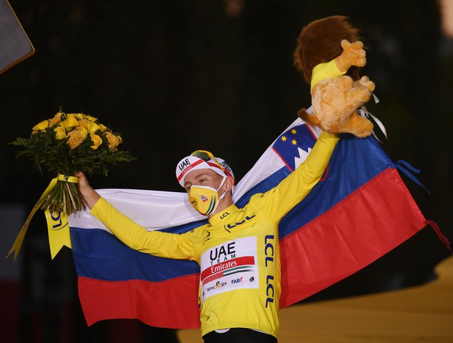Tadej Pogačar je na odru za zmagovalce Toura raztegnil slovensko trobojnico. Kako bo na SP? FOTO: Marco Bertorello/AFP