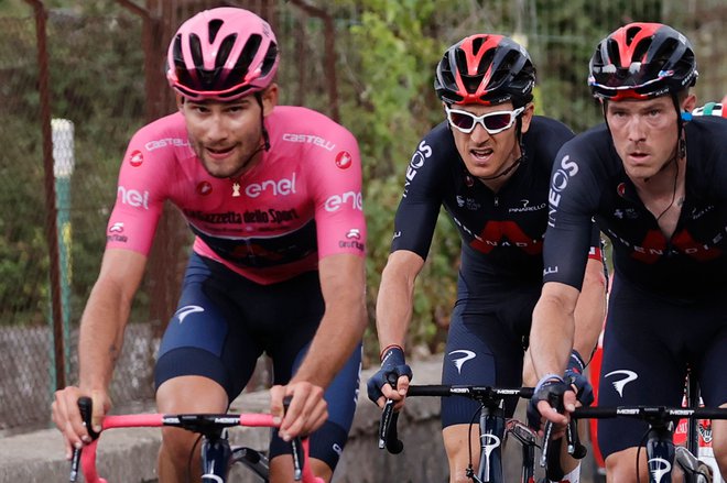 Zmagovalec uvodne vožnje na čas Filippo Ganna je v rožnati majici nemočnemu Geraintu Thomasu (v sredini) pomagal proti vrhu Etne. FOTO: Luca Bettini/AFP