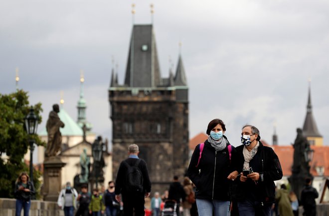 Po Karlovem mostu v Pragi se lahko ljudje sprehajajo le v zaščitnih maskah. Foto: David W Cerny/Reuters