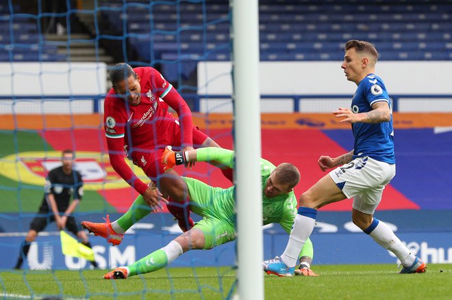 Virgil Van Dijk (v rdečem) se je poškodoval pri trčenju z vratarjem Evertona Jordana Pickforda. FOTO: Peter Byrne/AFP