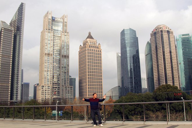 Šanghajska panorama z moškim, ki vadi tai chi. Ljudje, ki telovadijo, plešejo ali pojejo, niso na Kitajskem prav nič sramežljivi. FOTO: Mateja Toplak