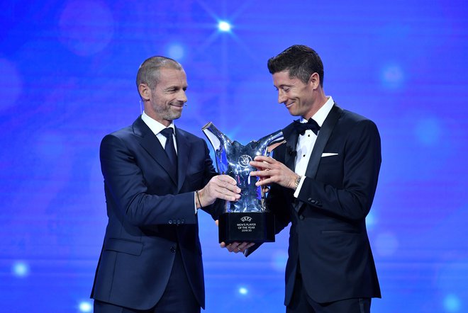 Robert Lewandowski (desno) je iz rok predsednika Uefe Aleksandra Čeferina oktobra prejel nagrado za najboljšega igralca v Evropi. Revija France Football, ki podeljuje zlato žogo, bo letos ubrala drugačno pot. FOTO: Reuters