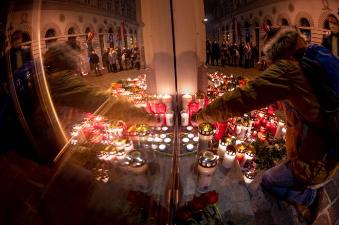 Ljudje na prizorišču strelskega napada na Dunaju prižigajo sveče v spomin petim žrtvam. FOTO: Joe Klamar/AFP