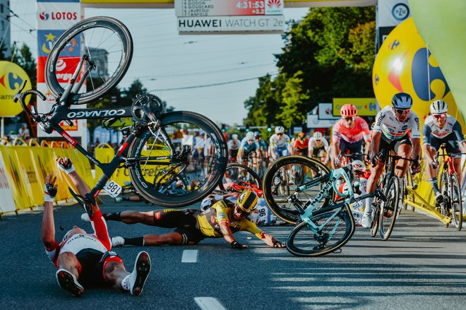 V ciljnem kaosu šprinta prve etape dirke po Poljskem jo je v padcu, v sredini Dylan Groenewegen, najbolj skupil Fabio Jakobsen. FOTO: Szymon Gruchalski/AFP