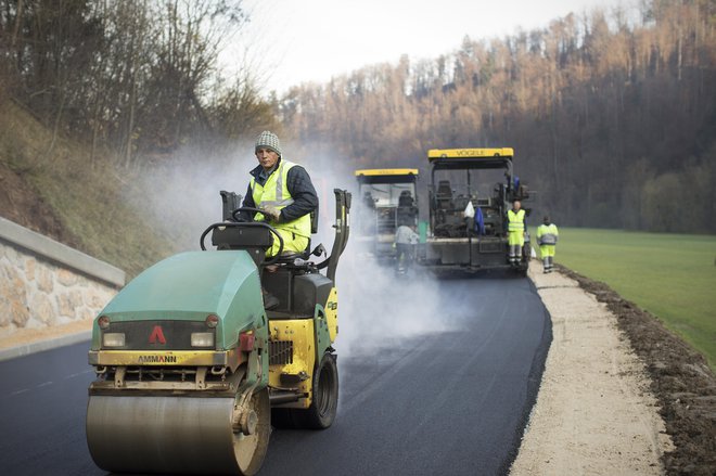 Polaganje finega sloja asfalta v Logu pri Polhovem Gradcu. FOTO: Jure Eržen/Delo