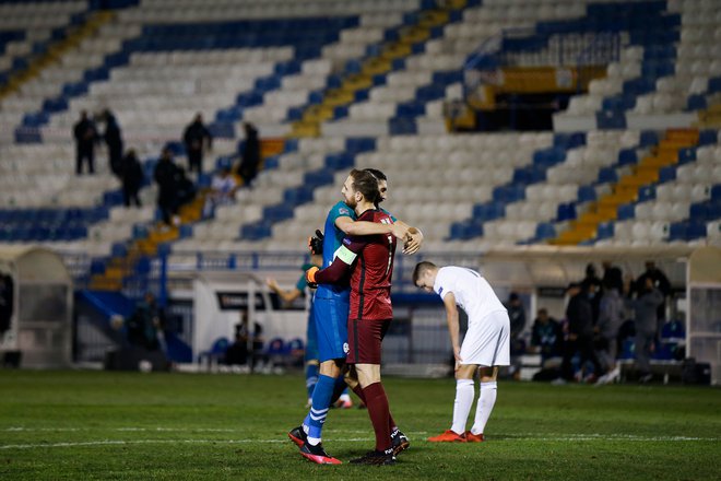 Tudi Miha Mevlja in Jan Oblak sta se veselo objela po tekmi v Atenah. FOTO: Alkis Konstantinidis/AFP