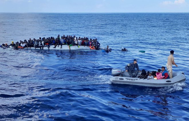 Migranti na gumijastem čolnu pred libijsko obalo oktobra letos. FOTO: Stringer/Reuters