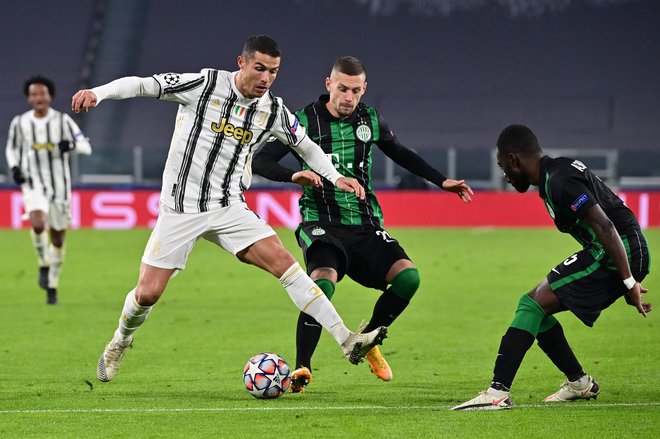 Cristiano Ronaldo (levo) je na tekmi s Ferencvarosem zabil že svoj 131. gol v ligi prvakov. FOTO: Miguel Medina/AFP