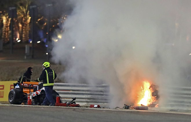 Gasilci so imeli precej dela, da so pogasili zublje z dirkalnika Romaina Grosjeana, ki ga je prelomilo na pol. FOTO: Tolga Bozoglu/AFP