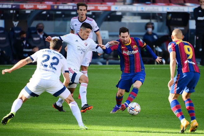 Lionel Messi med eno od zanj značilnih akcij med tekmo z Osasuno. FOTO: Lluis Gene/AFP