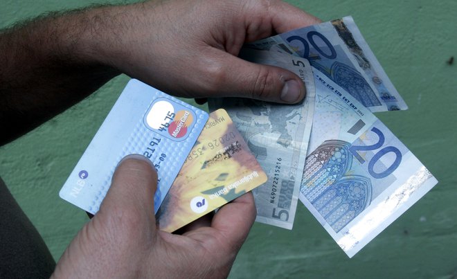 Slovenci še vedno najraje plačujemo z gotovino, je pa pandemija pospešila uporabo kartic. FOTO: Voranc Vogel/Delo