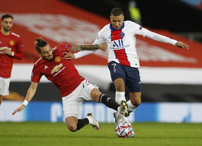 Derbi večera so igrali v Manchestru, kjer gostuje PSG. Takole sta se v eni od akcij borila Alex Telles in Kylian Mbappe. FOTO: Phil Noble/Reuters