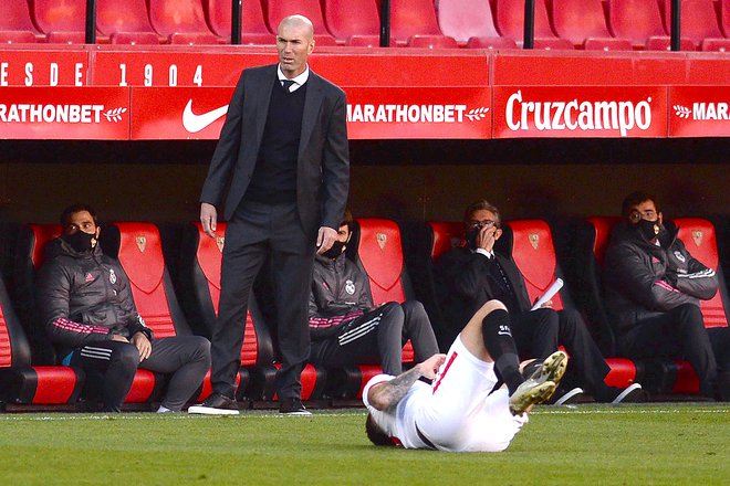 Realov trener Zinedine Zidane je preživel gostovanje v Sevilli in se bo pred velikim mestnim derbijem, ki bo v torek, 15. t. m., z novo grožnjo po odstrelu soočil v sredo ligi prvakov. FOTO: Cristina Quicler/AFP