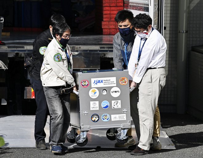 Kapsulo odpirajo v znanstvenem centru v Sagamihari na Japonskem. FOTO: Kyodo/Reuters