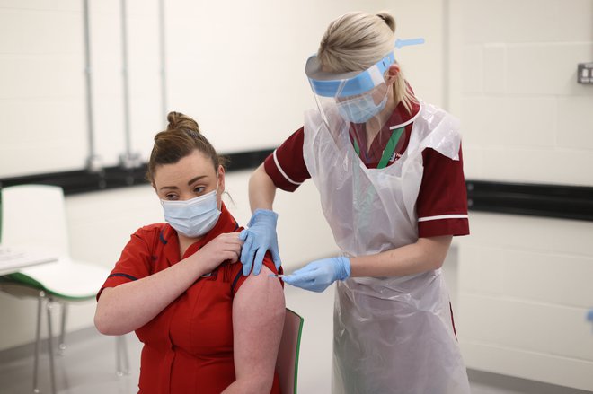 V Sloveniji naj bi se cepljenje proti covidu-19 začelo na začetku prihodnjega leta. Na fotografiji: cepljenje na Severnem Irskem. Foto Liam McBurney/AFP