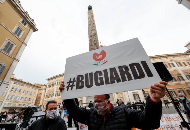 Nasprotnik ukrepov za preprečitev širjenja okužb med protestom pred sedežem spodnjega doma italijanskega parlamenta v Rimu. V rokah drži transparent z napisom &raquo;lažnivci&laquo;. Foto: Yara Nardi/Reuters