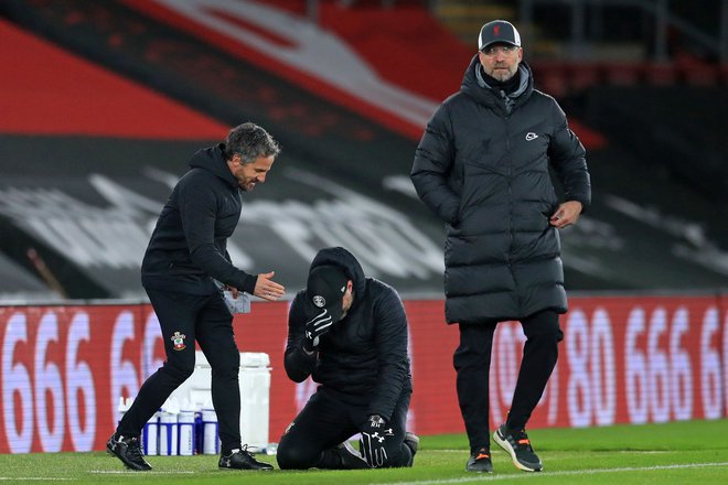 Southamptonov trener Ralph Hasenhüttl v solzah sreče na kolenih, Liverpoolov Jürgen Klopp pa ob porazu ne skriva razočaranja.<br />
FOTO: Adam Davy/AFP