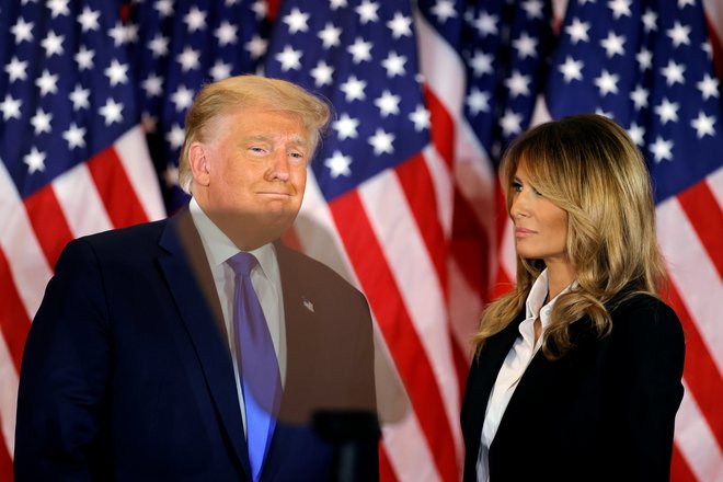 Razočarani ameriški predsednik v odhodu in njegova menda vesela soproga Melania. FOTO: Carlos Barria/Reuters