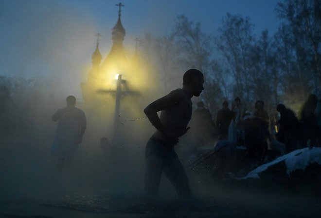 Utrinek iz ruskega mesta Omsk med potopom v mrzlo reko med praznovanjem pravoslavnega praznika Svetih treh kraljev. Verjamejo, da blagoslovljena mrzla voda očisti grehov tako njihovo telo kot duha. FOTO: Alexey Malgavko/Reuters