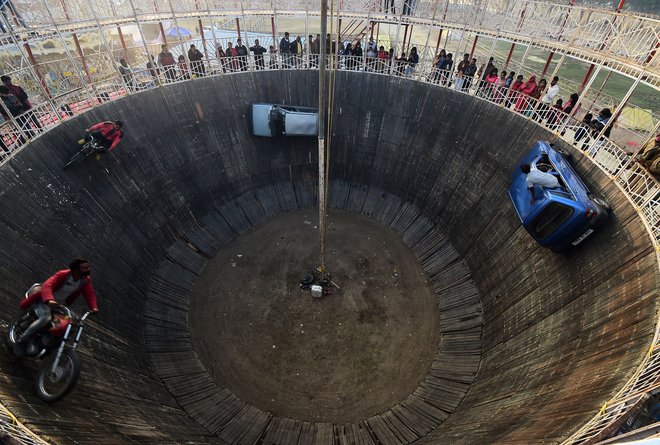 Na festivalu Magh Mela v Allahabadu so kaskaderji z avtomobili in motorji izvajali neverjetne vragolije na tako imenovanem zidu smrti. FOTO: Sanjay Kanojia/Afp