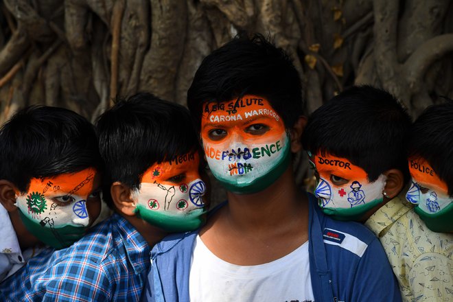 V Mumbaju so si študentje poslikali obraze, da se poklonijo zdravsvenim delavcem, ki se borijo proti širjenju koronavirusa Covid-19, pred prihajajočim praznovanjem dneva republike. FOTO: Indranil Mukherjee/Afp