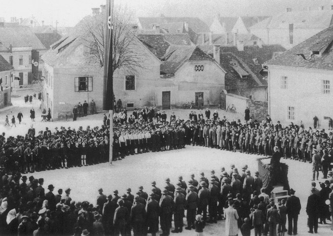 Govornik na Aškerčevem trgu (takrat Trg Adolfa Hitlerja) najverjetneje leta 1942 naj bi bil okrožni vodja Anton Dorfmeister, na oknu Bastove hiše pa je stala Pauline. FOTO: osebni arhiv Martina Pollacka