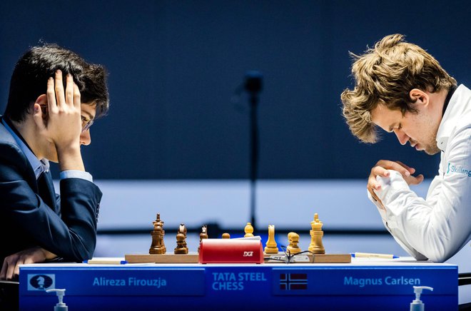 Iranski čudežni deček Alireza Firouzja in svetovni prvak Magnus Carlsen med turnirjem na Nizozemskem. FOTO: Remko De Waal/AFP