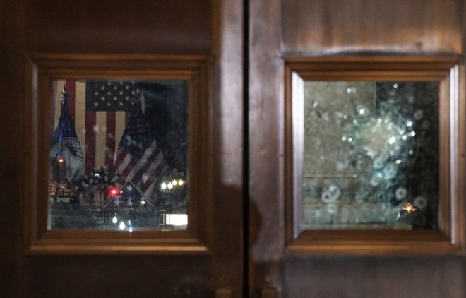 Vrata v ameriški kongres, kjer so vdrli Trumpovi privrženci, so še vedno razbita, v bližini spomin na padlega policista Briana Sicknicka. Foto Salwan Georges/Afp