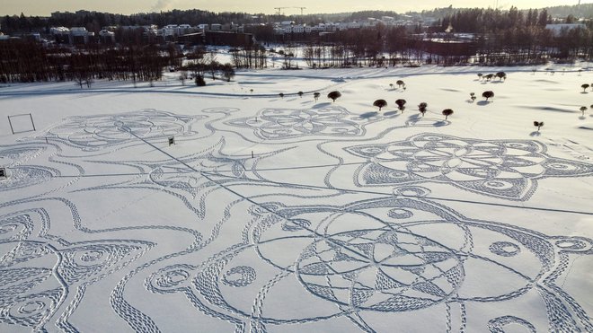 Na zasneženem igrišču za golf pred finsko prestolnico Helsinki je po zamisli Janneja Pyykköja skupina dvanajstih prostovoljcev z dolgimi vrvmi ustvarilo pravcato umetniško delo, ki meri 160 metrov v širino in je verjetno največja tovrstna umetnina v katerikoli od nordijskih držav. FOTO: Sam Kingsley/Afp