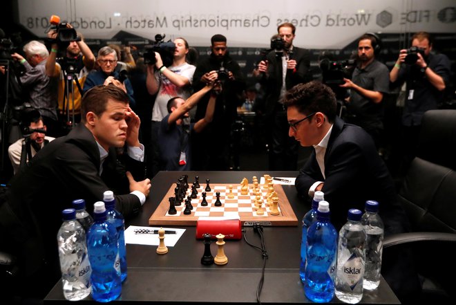 Magnus Carlsen in Fabiano Caruana med eno od partij. FOTO: Paul Childs/Reuters