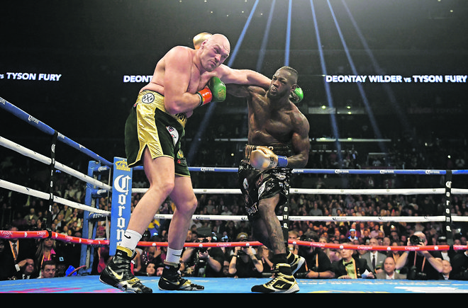 Ameriški boksarski šampion Deontay Wilder (desno) je s silovitimi udarci dvakrat spravil na tla svojega britanskega izzivalca Tysona Furyja. FOTO: AP
