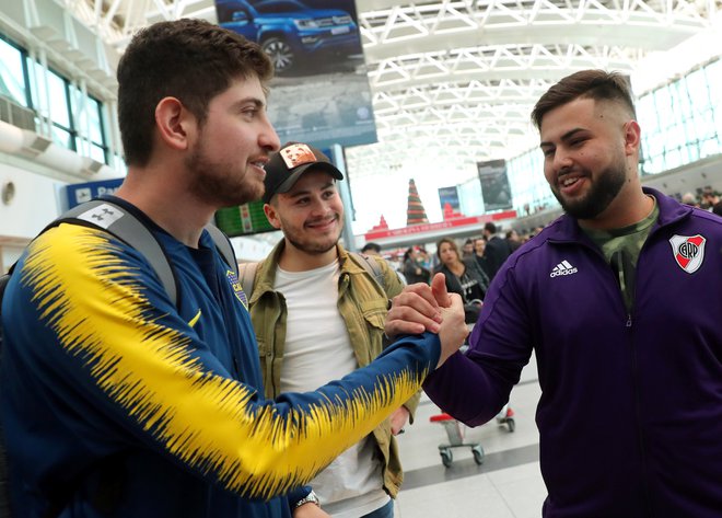 Navijača Boce Juniors in River Plata sta bila pred odhodom v Madrid na letališču v Buenos Airesu še navidezna prijatelja. FOTO: Reuters